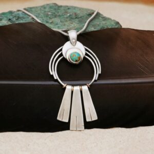 Pendentif en argent et turquoise posé sur une plume noire — création unique bijou artisanal Bordeaux Eliz'art