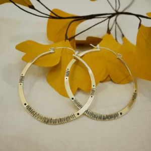 Grandes créoles en laiton gravé patiné et argent 950 posées sur feuilles jaunes — bijou artisanal fait main Bordeaux Eliz'art