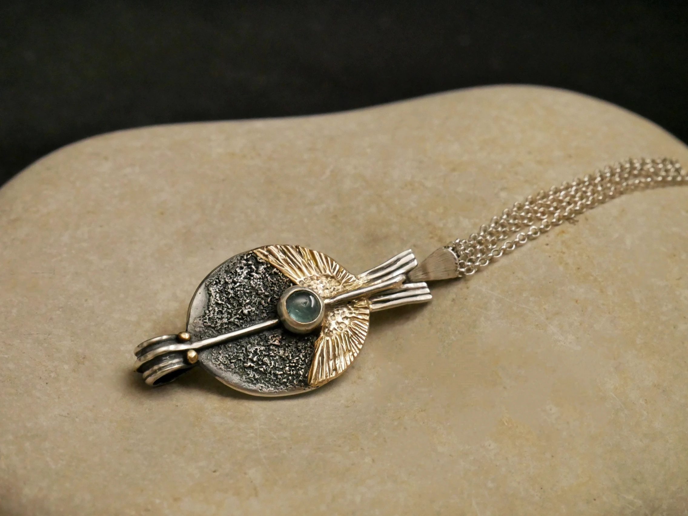 Pendentif orfèvre Eliz'art – œuf d'argent 950, ailes or 14k déployées, axe vertical et tourmaline bleue, création unique Bordeaux