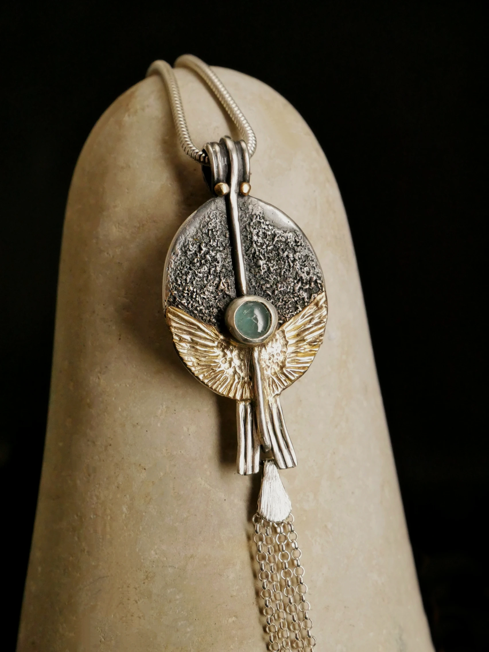 Pendentif orfèvre Eliz'art – œuf d'argent 950, ailes or 14k déployées, axe vertical et tourmaline bleue, création unique Bordeaux