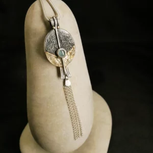 Pendentif orfèvre Eliz'art – œuf d'argent 950, ailes or 14k déployées, axe vertical et tourmaline bleue, création unique Bordeaux