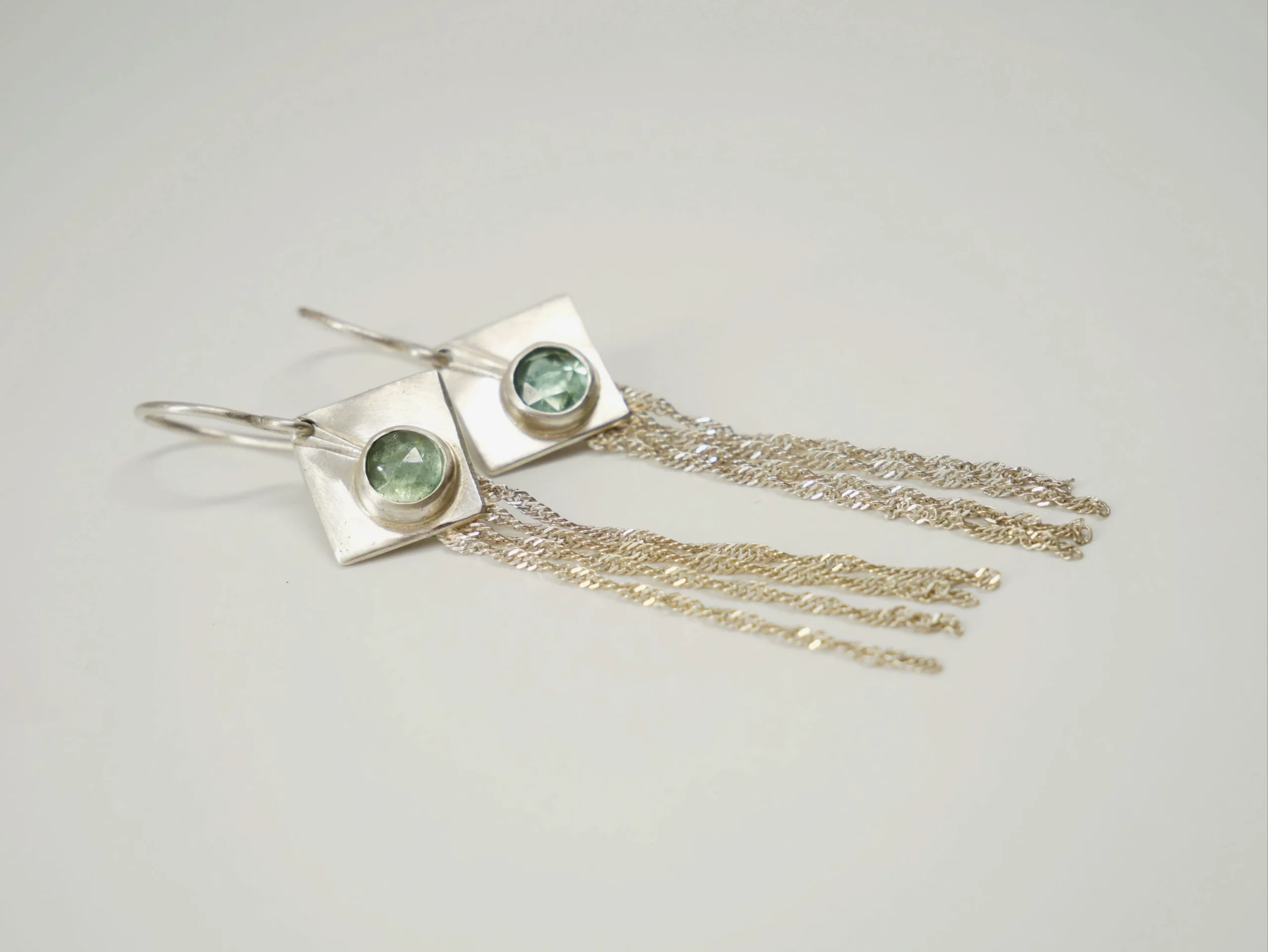 Boucles d'oreilles pendantes avec losange en argent brossé serti de cyanites vertes et fines chaînettes en argent. Bijou de créateur par Eliz'art, Bordeaux