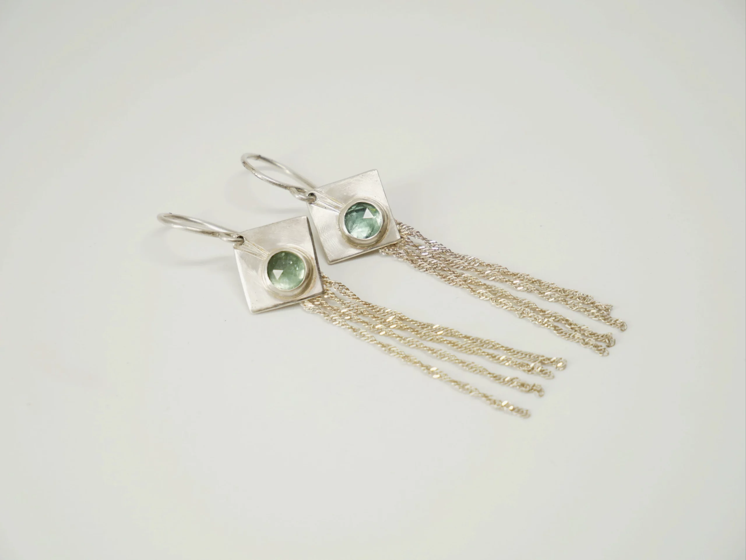Boucles d'oreilles pendantes avec losange en argent brossé serti de cyanites vertes et fines chaînettes en argent. Bijou de créateur par Eliz'art, Bordeaux
