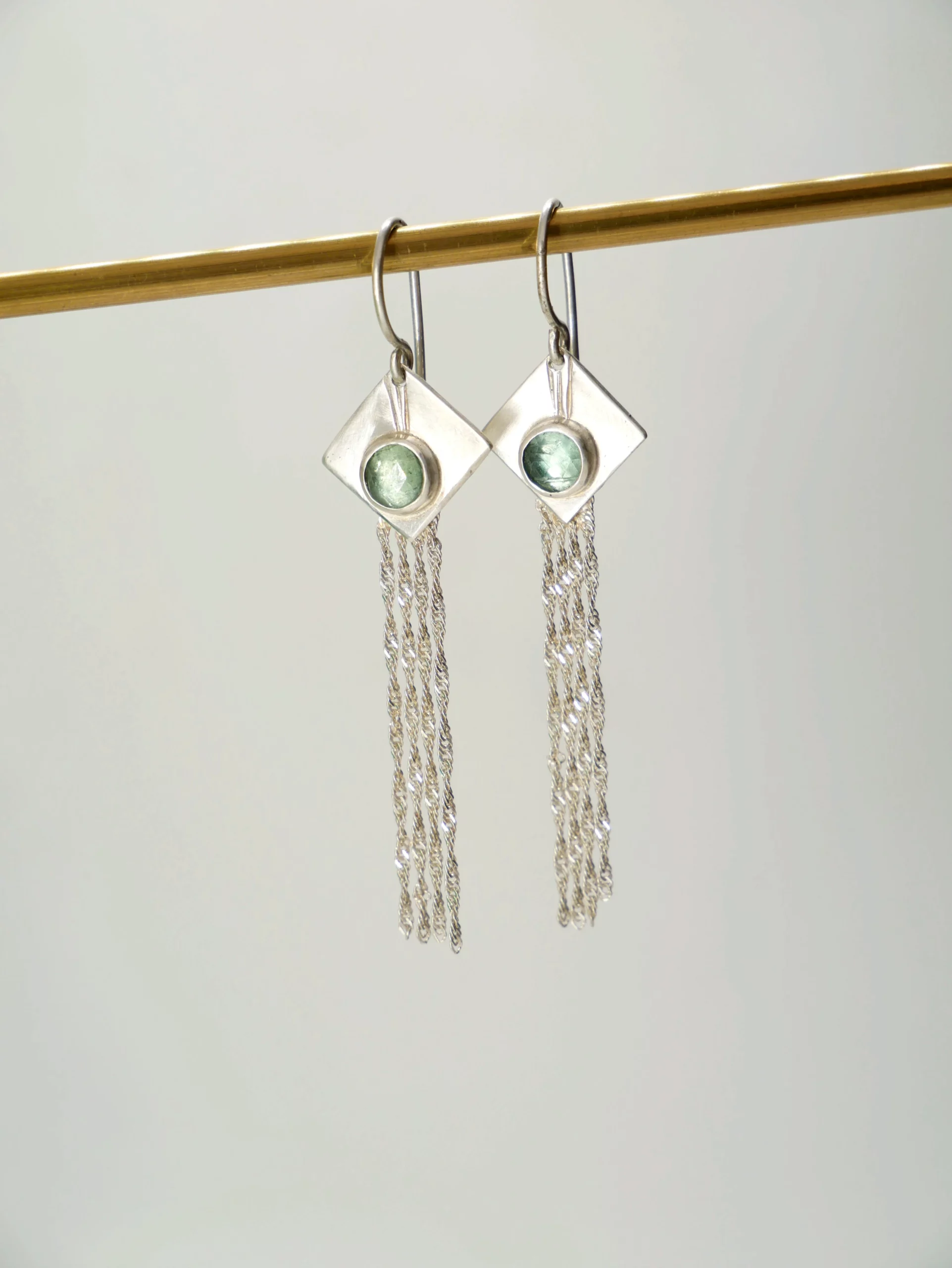 Boucles d'oreilles pendantes avec losange en argent brossé serti de cyanites vertes et fines chaînettes en argent. Bijou de créateur par Eliz'art, Bordeaux