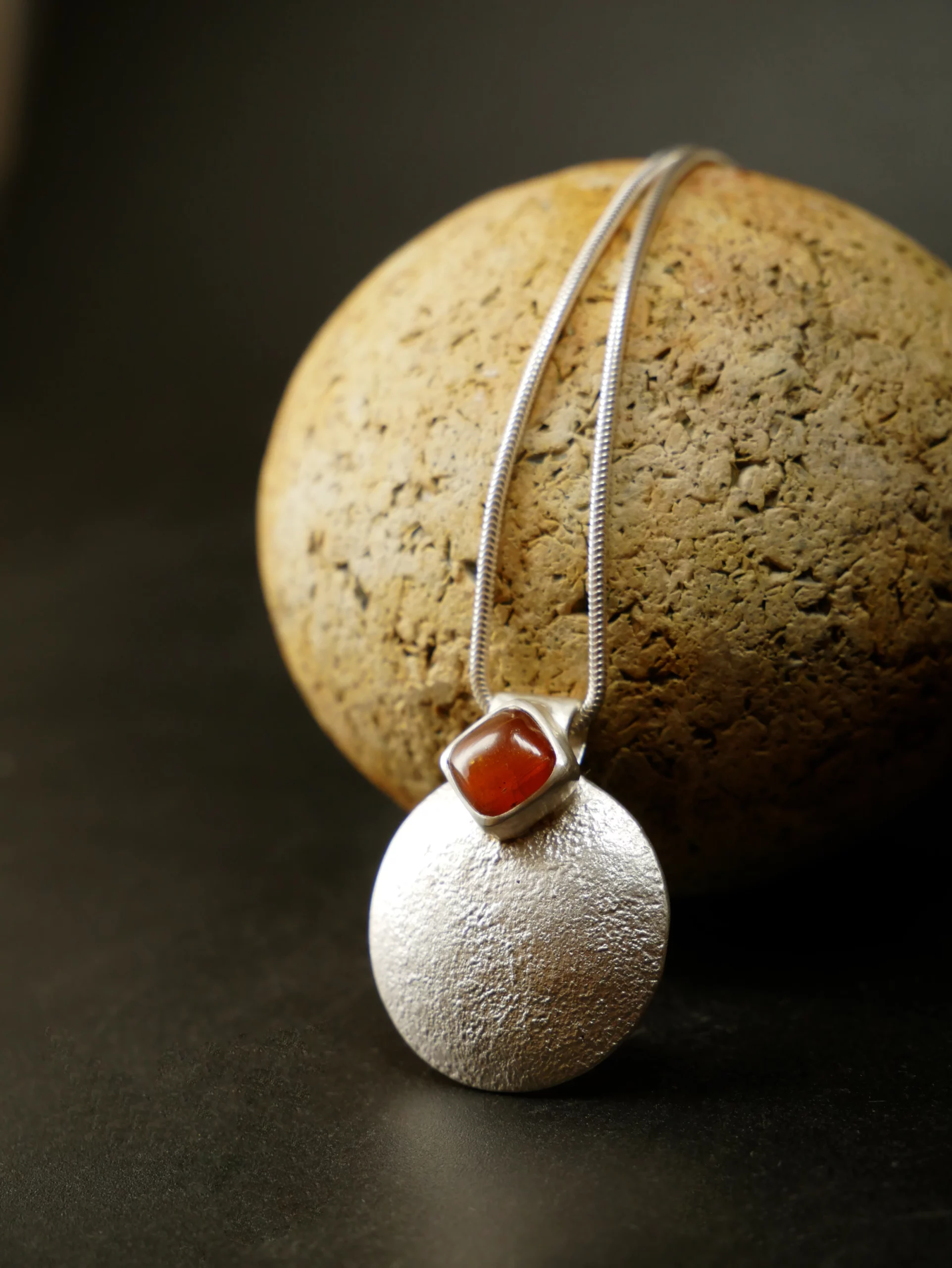 Pendentif en argent texturé, aspect lunaire, avec cyanite orange. Pièce unique faite main à Bordeaux par Eliz'art
