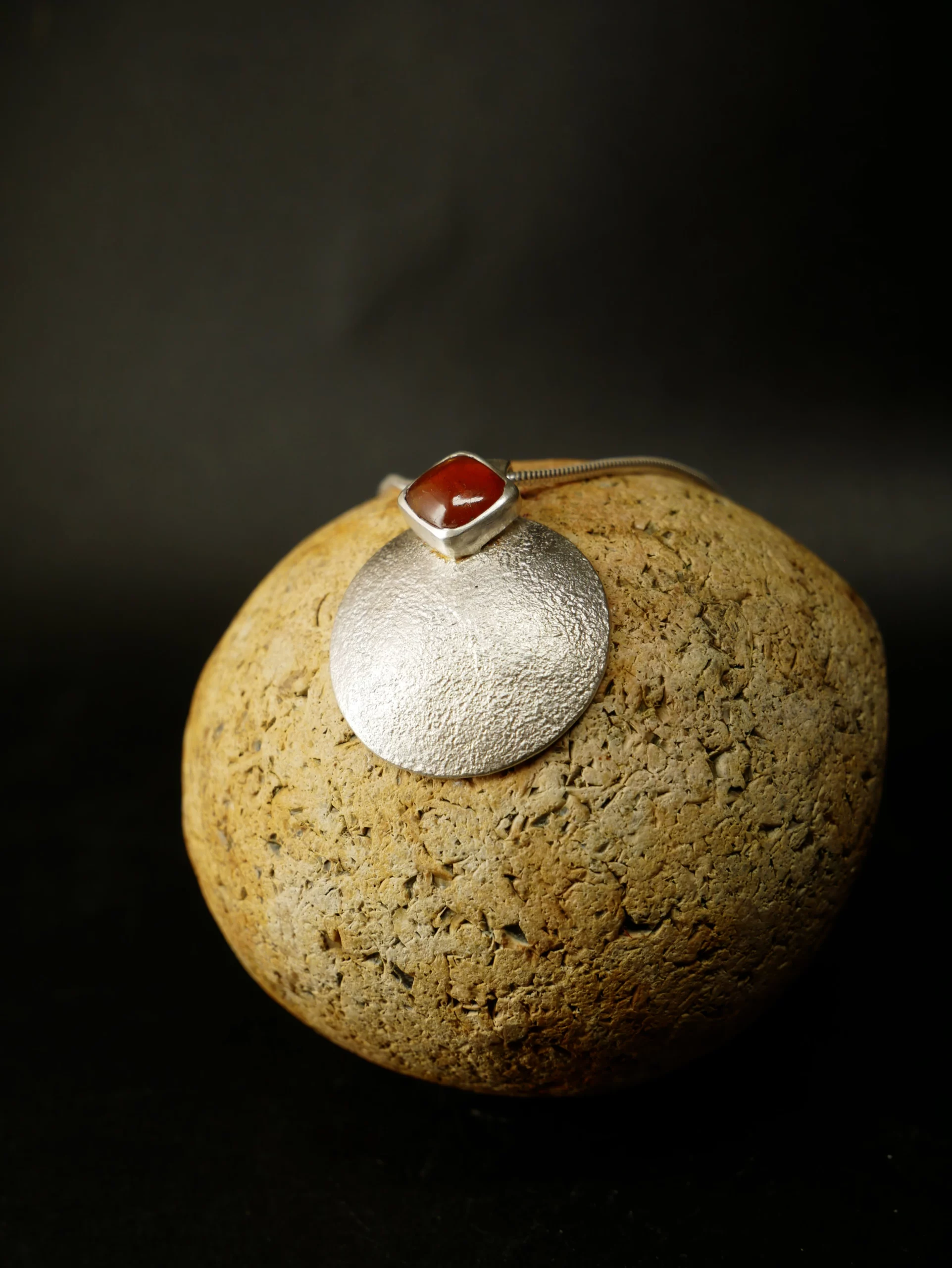Pendentif en argent texturé, aspect lunaire, avec cyanite orange. Pièce unique faite main à Bordeaux par Elizart