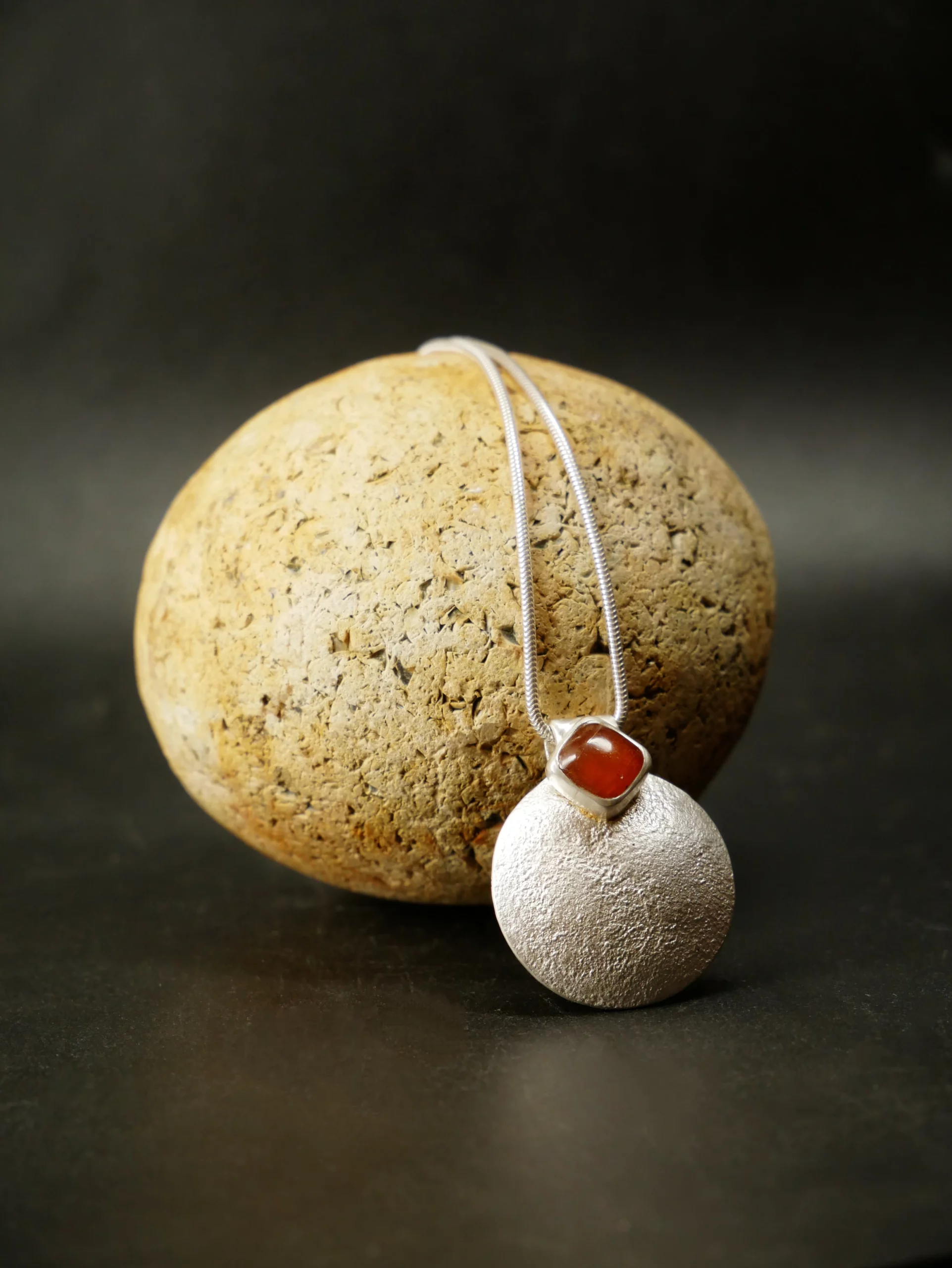 Pendentif en argent texturé, aspect lunaire, avec cyanite orange. Pièce unique faite main à Bordeaux par Eliz'art