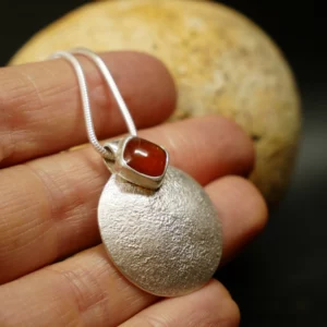 Pendentif en argent texturé, aspect lunaire, avec cyanite orange. Pièce unique faite main à Bordeaux par Eliz'art