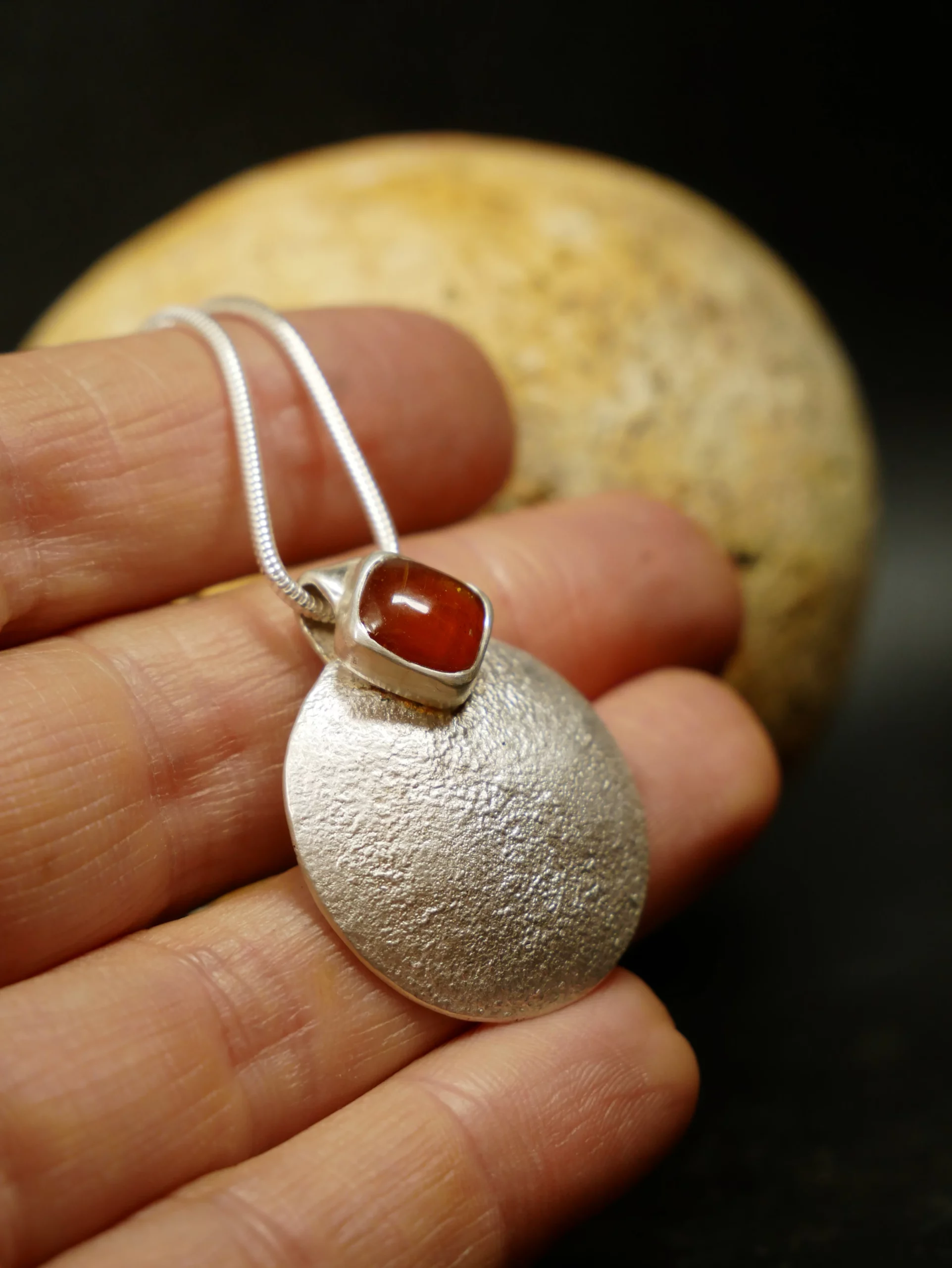 Pendentif en argent texturé, aspect lunaire, avec cyanite orange. Pièce unique faite main à Bordeaux par Eliz'art