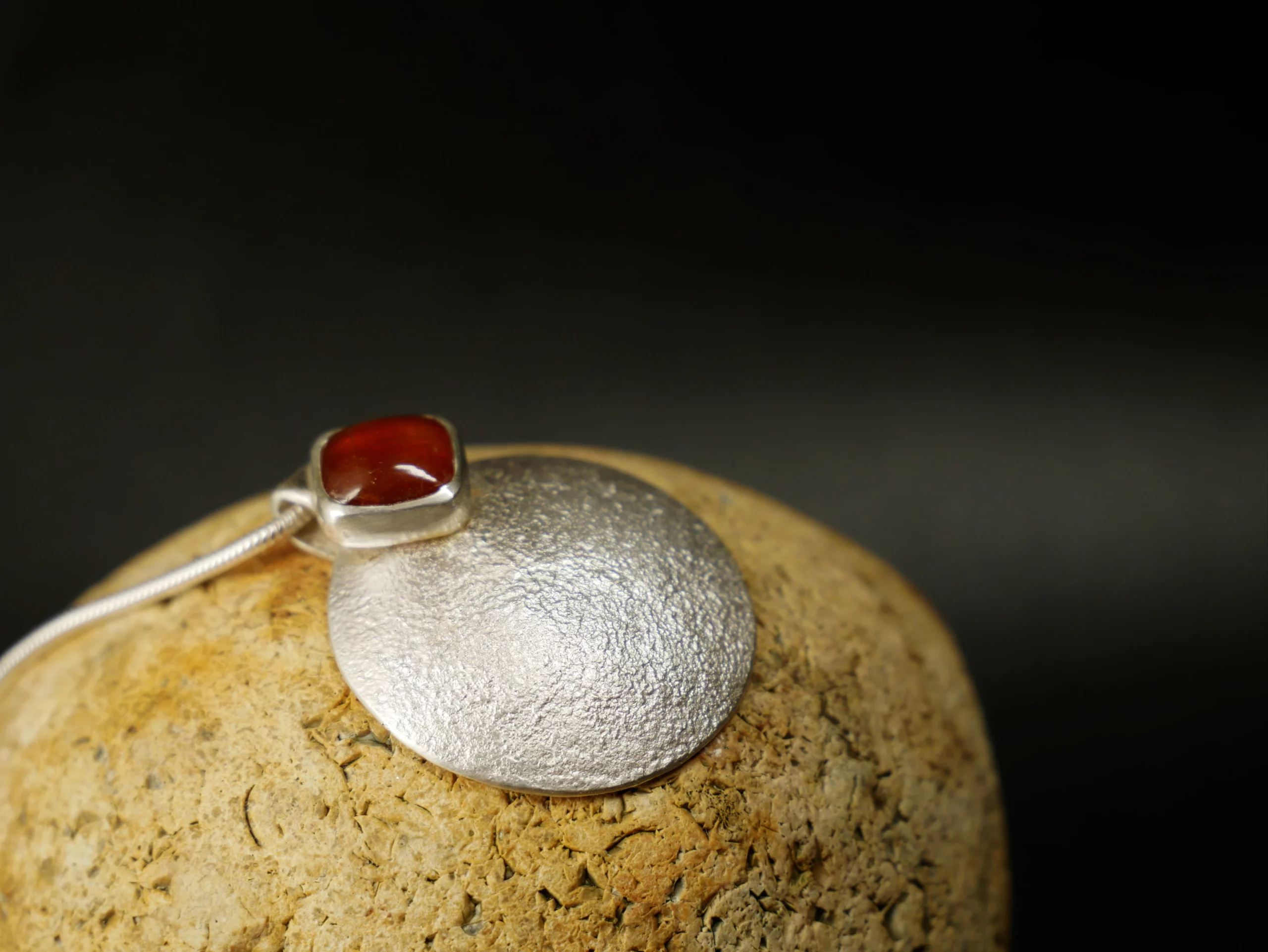 Pendentif en argent texturé, aspect lunaire, avec cyanite orange. Pièce unique faite main à Bordeaux par Eliz'art