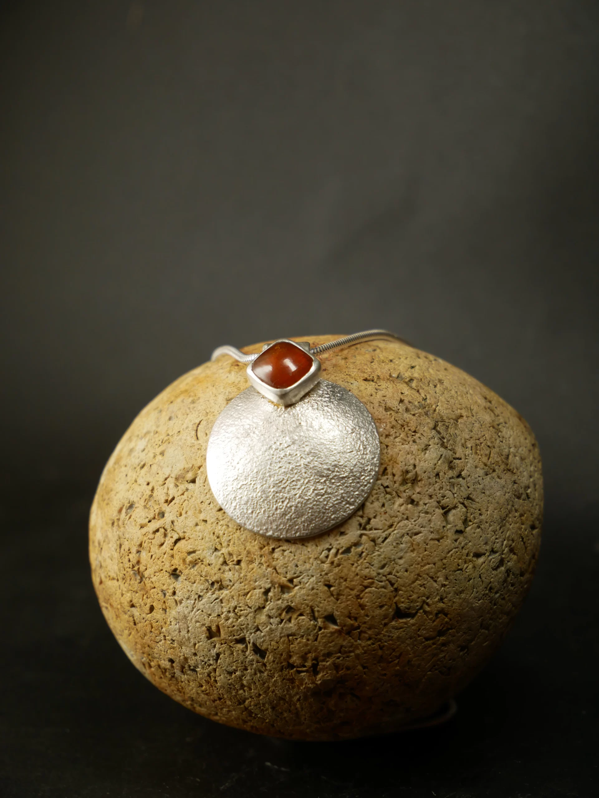 Pendentif en argent texturé, aspect lunaire, avec cyanite orange. Pièce unique faite main à Bordeaux par Eliz'art