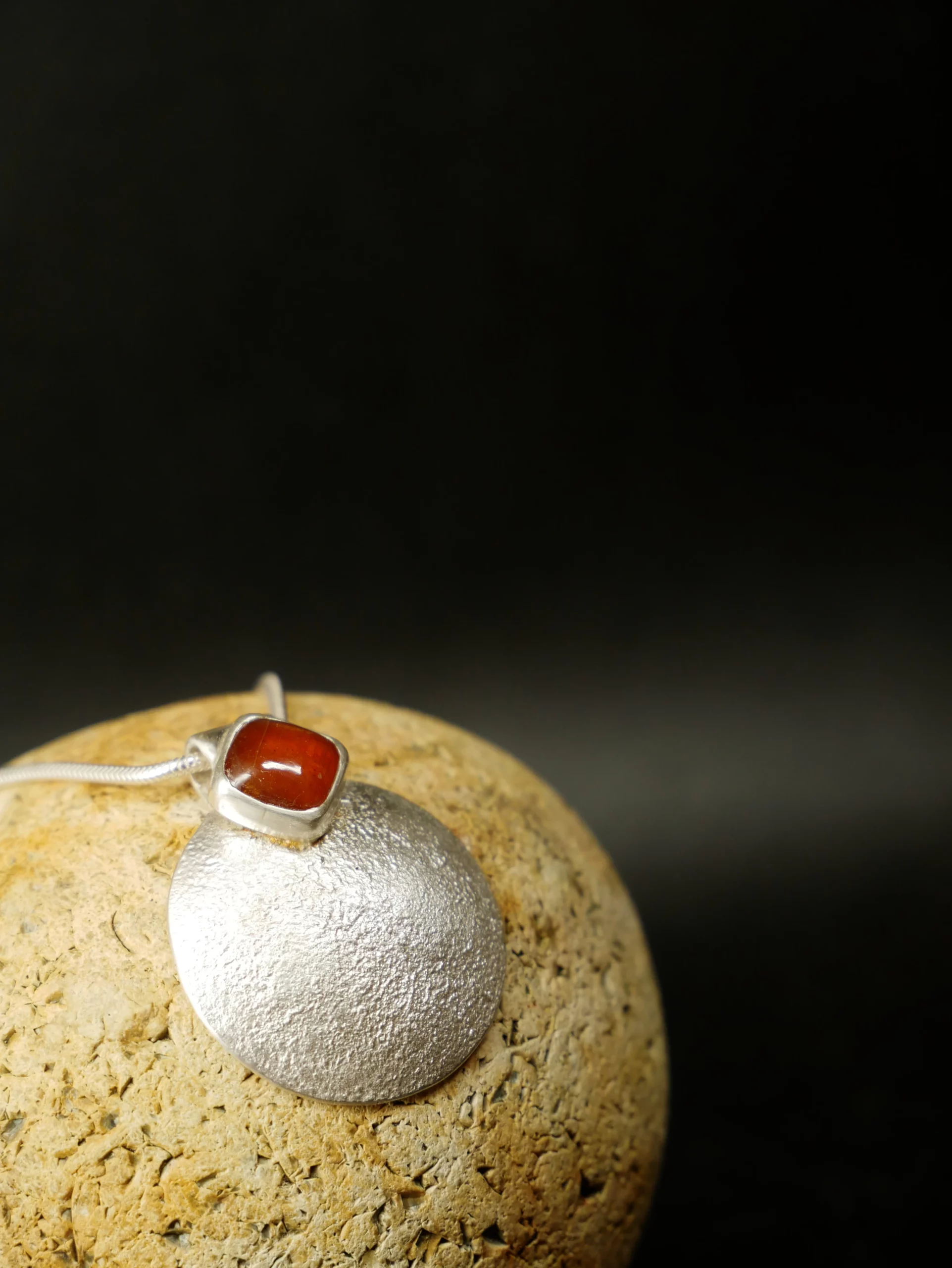 Pendentif en argent texturé, aspect lunaire, avec cyanite orange. Pièce unique faite main à Bordeaux par Elizart